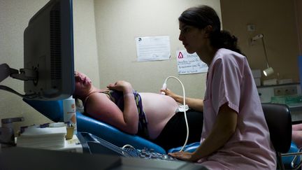 Une femme enceinte passe une échographie, à Argenteuil (Val-d'Oise), le 22 juillet 2013.&nbsp; (FRED DUFOUR / AFP)