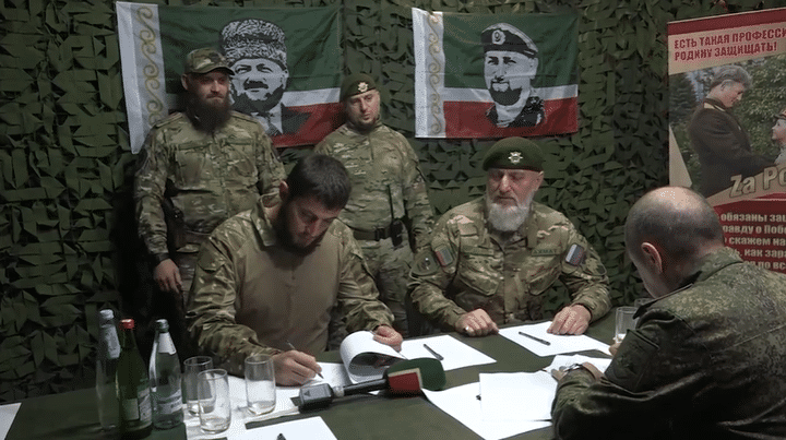 Des représentants du bataillon tchétchène Akhmat signent un contrat avec l'armée russe, le 12 juin 2023, dans une vidéo publiée par Ramzan Kadyrov. (RAMZAN KADYROV / TELEGRAM)