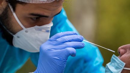 Un soignant effectue un prélèvement naso-pharyngé sur un patient dans le centre-ville de Toulouse, le 29 septembre 2020. (FREDERIC SCHEIBER / HANS LUCAS)