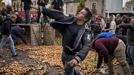 Un manifestant lance une pomme de terre lors d'un rassemblement d'agriculteurs, le 5 novembre 2014 &agrave; Dijon (C&ocirc;te d'Or). (JEFF PACHOUD / AFP)