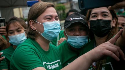 Sara Duterte (à gauche), maire et fille du président philippin sortant Rodrigo Duterte, fait un selfie avec des employés de la mairie dans la ville de Davao, sur l'île méridionale de Mindanao (Philippines). (MANMAN DEJETO / AFP)