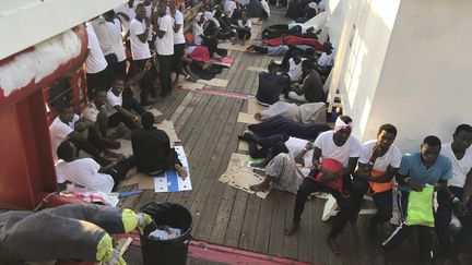 Des migrants sur le navire "Ocean Viking" exploité par les ONG françaises SOS Méditerranée et Médecins sans Frontières (MSF),&nbsp;le 12 août 2019.&nbsp; (ANNE CHAON / AFP)