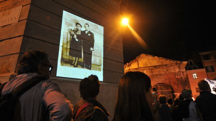 Photo de déportés projetée sur un mur lors d'une marche silencieuse en mémoire des victimes de la rafle du ghetto de Rome, le 16 octobre 2013. (TIZIANA FABI / AFP)