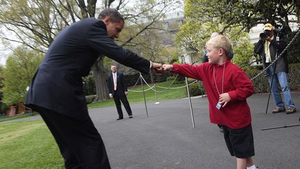 Le pr&eacute;sident des Etats-Unis, Barack Obama, salue un enfant par un "check", le 19 avril 2009 &agrave; Washington. (AUDE GUERRUCCI / AFP)