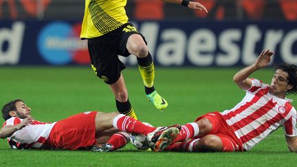 Les joueurs de l'Olympiakos Djamel Abdoun et Fran&ccedil;ois Modesto tentent de barrer le passage &agrave; l'attaquant de Dortmund Kevin Grosskreutz lors de leur match en Ligue des champions le 1er novembre 2011, en Allemagne.&nbsp; (PATRIK STOLLARZ / AFP)