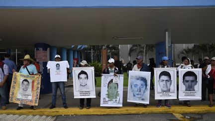 Des manifestants posent avec des portraits des &eacute;tudiants disparus &agrave; Iguala, lors d'une manifestation devant l'a&eacute;roport international d'Acapulco (Mexique), le 10 novembre 2014. (RONALDO SCHEMIDT / AFP)