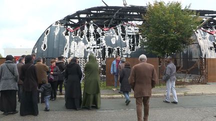 Des habitants de&nbsp;Chanteloup-les-Vignes (Yvelines) rassemblés devant le chapiteau incendié, le 3 novembre 2019.&nbsp; (PIERRE RATEAU / AFP)