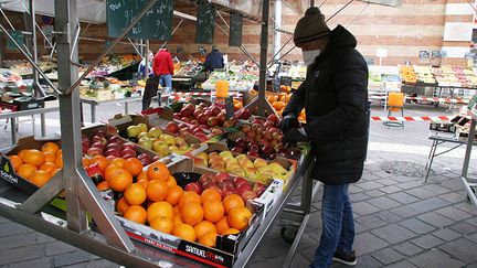 Un homme dans un marché en plein air de Grenoble (Isère), le 31 mars 2020. (MAXPPP)