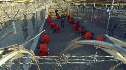 Les premiers d&eacute;tenus sont arriv&eacute;s le 11 janvier 2002. V&ecirc;tus d'une combinaison orange, encagoul&eacute;s et menott&eacute;s, ils &eacute;taient d&eacute;tenus dans des cages &agrave; l'air libre dans le camp &laquo; X-Ray &raquo;. (REUTERS)