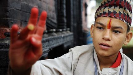 Au temple Pashupatinath, un jeune prêtre appose un tika, porte-bonheur symbolisant le troisième œil, sur le front des pèlerins.  
 
A l’origine, seuls les dieux et les ascètes avaient le droit de porter ce signe, mais aujourd’hui c’est une pratique largement adoptées par de nombreux hindous.

  (  AFP PHOTO / Prakash MATHEMA)