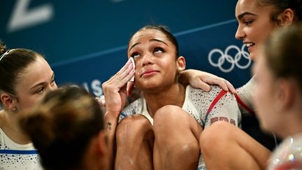 La gymnaste française Mélanie de Jésus dos Santos consolée par ses coéquipières à l'Arena de Bercy, à Paris, le 28 juillet 2024. (LOIC VENANCE / AFP)