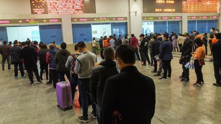 Des voyageurs patientent à la gare de Yichang, dans le Hubei, le 25 mars 2020. (AFP)