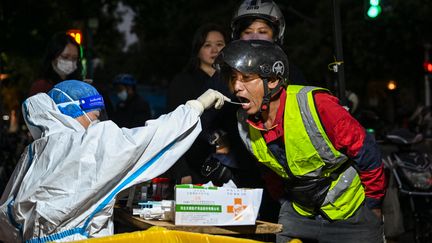 Un homme se fait tester dans la rue à Shanghai, le 8 octobre 2022.&nbsp; (HECTOR RETAMAL / AFP)