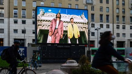 Dans le centre ville de Milan en Italie un écran permet de voir les collections masculine automne-hiver 2021-22, présentées dans le cadre de la Milan Fashion Week, le 15 janvier 2021&nbsp; (MIGUEL MEDINA / AFP)