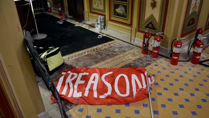 Une bannière "Trahison" abandonnée par les émeutiers pro-Trump qui ont&nbsp;forcé l'entrée du Capitole mercredi 6 janvier au soir. (OLIVIER DOULIERY / AFP)