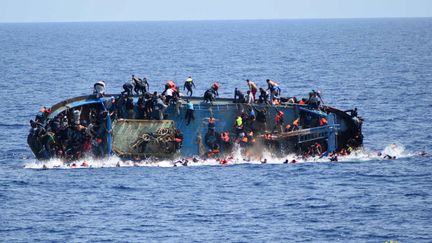 Photo communiquée par la marine italienne montrant des migrants tentant d'échapper au naufrage de leur navire, le 25 mai 2016 au large des côtes libyennes. (MARINA MILITARE / AFP)