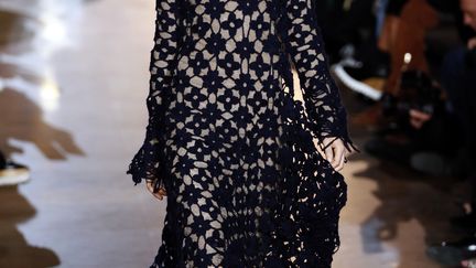 Stella McCartney a présenté une collection hommage à la "liberté" et à la "sensualité". Aux lignes simples et fluides sont associées des silhouettes aux manches, pantalons ou ourlets ultra-longs. Les robes noires, aux épaules étroites et à la taille marquée, complètent un dressing aux coupes masculines et près du corps. Écologiste de la première heure, Stella McCartney exclut toujours fourrure et cuir de ses collections. Mais la fausse fourrure est bien présente sous la forme de manteaux à poils longs, noirs ou ivoire. En soirée, la femme porte une robe sans bretelles, noire et blanche, à la taille bien marquée. 
 (PATRICK KOVARIK / AFP)