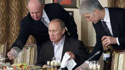 Evguéni Prigojine (à gauche) présente un plat à Vladimir Poutine, alors Premier ministre de Russie, dans l'un de ses restaurants près de Moscou (Russie), le 11 novembre 2011. (MISHA JAPARIDZE / AP / SIPA)