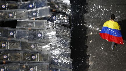 Un manifestant anti-gouvernement face aux policiers &agrave; Caracas (Venezuela), le 12 f&eacute;vrier 2014. (JORGE SILVA / REUTERS)