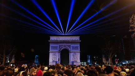 Les Parisiens&nbsp;célèbrent le Nouvel An, dans la nuit du 31 décembre 2014 au 1er janvier 2015, devant l'Arc de triomphe. (JALLAL SEDDIKI / CITIZENSIDE / AFP)