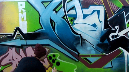 Le graffeur londonien KAES / RM en pleine expression "galactique" au BIG 2014
 (Capture d&#039;écran France 3/Culturebox)