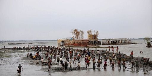 Des villageois reconstruisant l'embarquemenrt du quai, à Padmapukir, après un cyclone, le 3 juin 2009  l (AFP/MUNIR UZ ZAMAN)