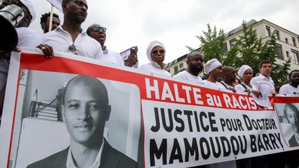 Une bannière "Halte au racisme - Justice pour le docteur Mamoudou Barry" brandie lors de la marche du 26 juillet 2019, en hommage au Guinéen décédé après une agression (LOU BENOIST / AFP)