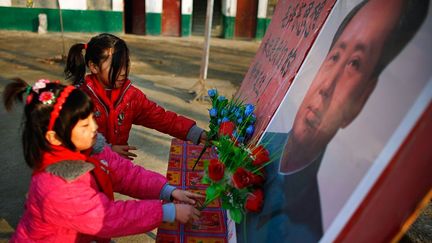 Avant le jour de la cérémonie, les filles ornent de fleurs en plastique les portraits de Mao… (Carlos Barria)