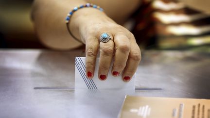 Une femme vote au r&eacute;f&eacute;rendum en Gr&egrave;ce, sur l'&icirc;le grec de Kastellorizo, dimanche 5 juillet 2015.&nbsp; (CATHAL MCNAUGHTON / REUTERS)