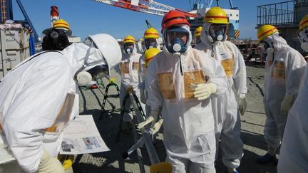 Le ministre japonais de l'Economie et de l'Industrie,&nbsp;Toshimitsu Motegi (casque rouge), &agrave; la centrale de Fukushima le 26 ao&ucirc;t 2013.&nbsp; (TEPCO / AFP)