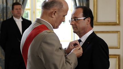 Apr&egrave;s 38 minutes d'entretien avec Nicolas Sarkozy, Fran&ccedil;ois Hollande (D) est elev&eacute; &agrave; la dignit&eacute; de Grand croix de la L&eacute;gion d'honneur par le g&eacute;n&eacute;ral Jean-Louis Georgelin. (FRED DUFOUR / AFP)