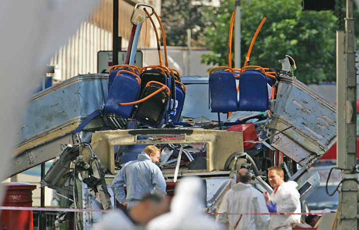 Des enquêteurs collectent des preuves a proximité du bus à impériale qui a été complètement soufflé par une bombe le 7 juillet 2005 à&nbsp;Tavistock Square, à Londres. (ODD ANDERSEN / AFP)