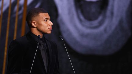 L'attaquant français du Paris Saint-Germain Kylian Mbappe remet le Ballon d'Or féminin lors de la cérémonie de remise des prix Ballon d'Or France Football 2021 au Théâtre du Châtelet à Paris le 29 novembre 2021 (FRANCK FIFE / AFP)