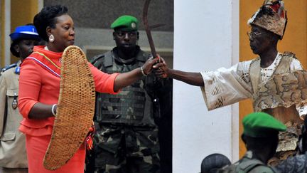 La nouvelle pr&eacute;sidente de Centrafrique Catherine Samba Panza (G)&nbsp;re&ccedil;oit d'un chef de tribu un bouclier et une &eacute;p&eacute;e lors de sa c&eacute;r&eacute;monie d'investiture &agrave; Bangui (Centrafrique), le 23 janvier 2014. (ISSOUF SANOGO / AFP)