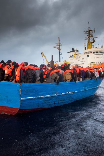 Des réfugiés entassés sur un bateau en bois non loin de l'"Aquarius", navire de sauvetage des ONG SOS Méditerranée et Médecins sans frontières, le 11 décembre 2016, en mer Méditerranée (LAURIN SCHMID/ SOS MEDITERRANEE / PICTURE ALLIANCE / AFP)