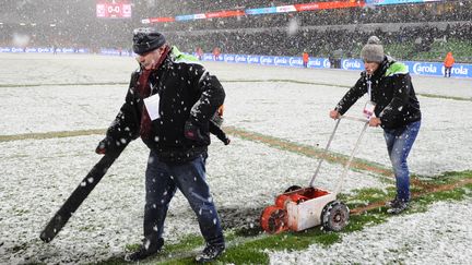 Des stadiers enl&egrave;vent la neige de la pelouse du stade Saint-Symphorien lors de Metz-Nice, le 31 janvier 2015.&nbsp; (JEAN-CHRISTOPHE VERHAEGEN / AFP)