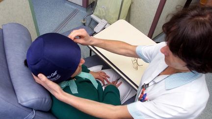 Mise en place d'un casque sp&eacute;cial qui permet au patient trait&eacute; par chimioth&eacute;rapie de perdre moins de cheveux,&nbsp;&agrave; l'h&ocirc;pital de Morlaix (Finist&egrave;re), le 12 septembre 2002. (CLAUDE PRIGENT / MAXPPP)