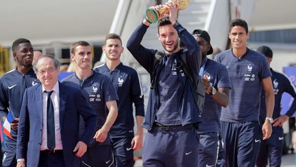 L'arrivée des Bleus à Roissy. Accompagné par ses coéquipiers et par le président de la Fédération Noël le Graët, le capitaine Hugo lloris brandi la Coupe du monde. (THOMAS SAMSON / AFP)