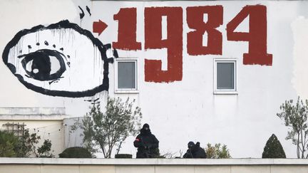 1984, publié en 1949, en graffiti sur le toit d'un immeuble à Paris pendant une manifestation (ETIENNE LAURENT / MAXPPP)