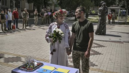 Un couple de soldats ukrainiens se marie à&nbsp;Druzhkivka, dans le Donbass (Ukraine), le 12 juin 2022. (ARIS MESSINIS / AFP)