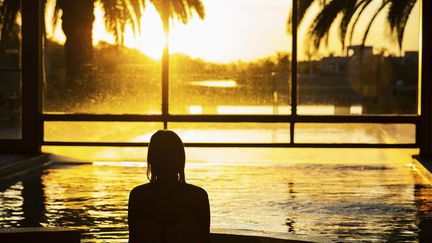 Une femme regarde le coucher de soleil depuis un jacuzzi. (MAXPPP)