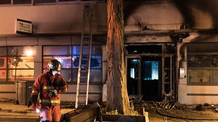 Un pompier intervient devant un commissariat incendié à Bagnolet (Hauts-de-Seine), le 29 juin 2023, lors de la deuxième nuit d'émeutes après la mort de Nahel à Nanterre. (GAUTHIER BEDRIGNANS / HANS LUCAS / AFP)