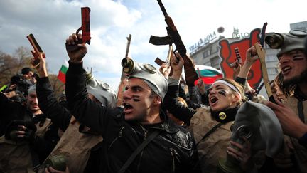 Des &eacute;tudiants brandissent des armes en carton lors d'une manifestation anti-gouvernementale devant le parlement &agrave; Sofia (Bulgarie), le 20 novembre 2013. (NIKOLAY DOYCHINOV / AFP)