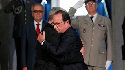 Les pr&eacute;sidents fran&ccedil;ais et allemand, Fran&ccedil;ois Hollande (D.)&nbsp;et Joachim Gauck se donnent l'accolade, lors du&nbsp;centenaire du d&eacute;but de la premi&egrave;re guerre mondiale sur le site du Hartmannswillerkopf (Haut-Rhin), le 3 ao&ucirc;t 2014.&nbsp; (THIBAULT CAMUS / AFP)