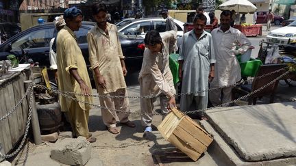 A Lahore, des Pakistanais observent l'endroit&nbsp;o&ugrave; une femme enceinte a &eacute;t&eacute; tu&eacute;e par lapidation. (ARIF ALI / AFP)