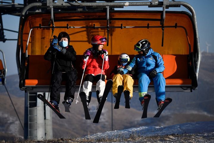 Des skieurs chinois sur un télésiège du site olympique du Genting Snow park, le 21 décembre 2021. (WANG ZHAO / AFP)