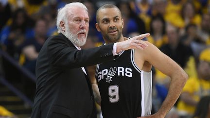 Tony Parker en concertation avec son coach Gregg Popovich, contre les Golden State Warriors à Oakland, le 14 avril 2018. (THEARON W. HENDERSON / AFP)