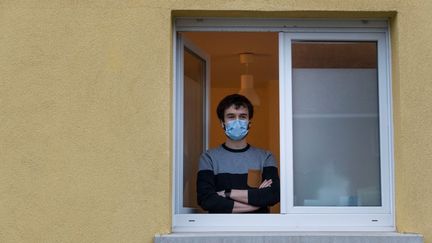 Jonathan Peterschmitt, un médecin infecté par le coronavirus, pose à la fenêtre de son cabinet médical, à&nbsp;Bernwiller (Haut-Rhin), le 4 mars 2020. (SEBASTIEN BOZON / AFP)