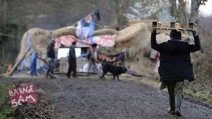 Un opposant transporte une palette de bois peu avant une barricade, sur le site du futur a&eacute;roport de Notre-Dame-des-Landes (Loire-Atlantique), le 11 d&eacute;cembre 2012. (JEAN-SEBASTIEN EVRARD / AFP)