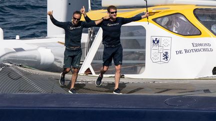 Les navigateurs français Franck Cammas (à gauche) et Charles Caudrelier, lors de leur arrivée à Fort-de-France le 23 novembre à bord du Maxi Edmond de Rothschild, en&nbsp;vainqueur de la Transat Jacques Vabre dans la catégorie Ultim. (LOIC VENANCE / AFP)